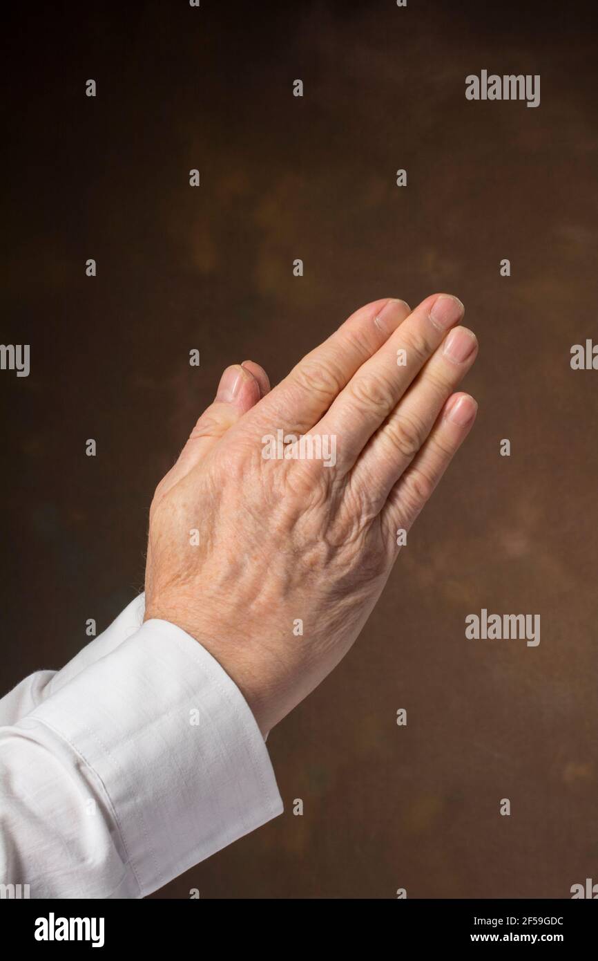 Man's hands in praying position Stock Photo