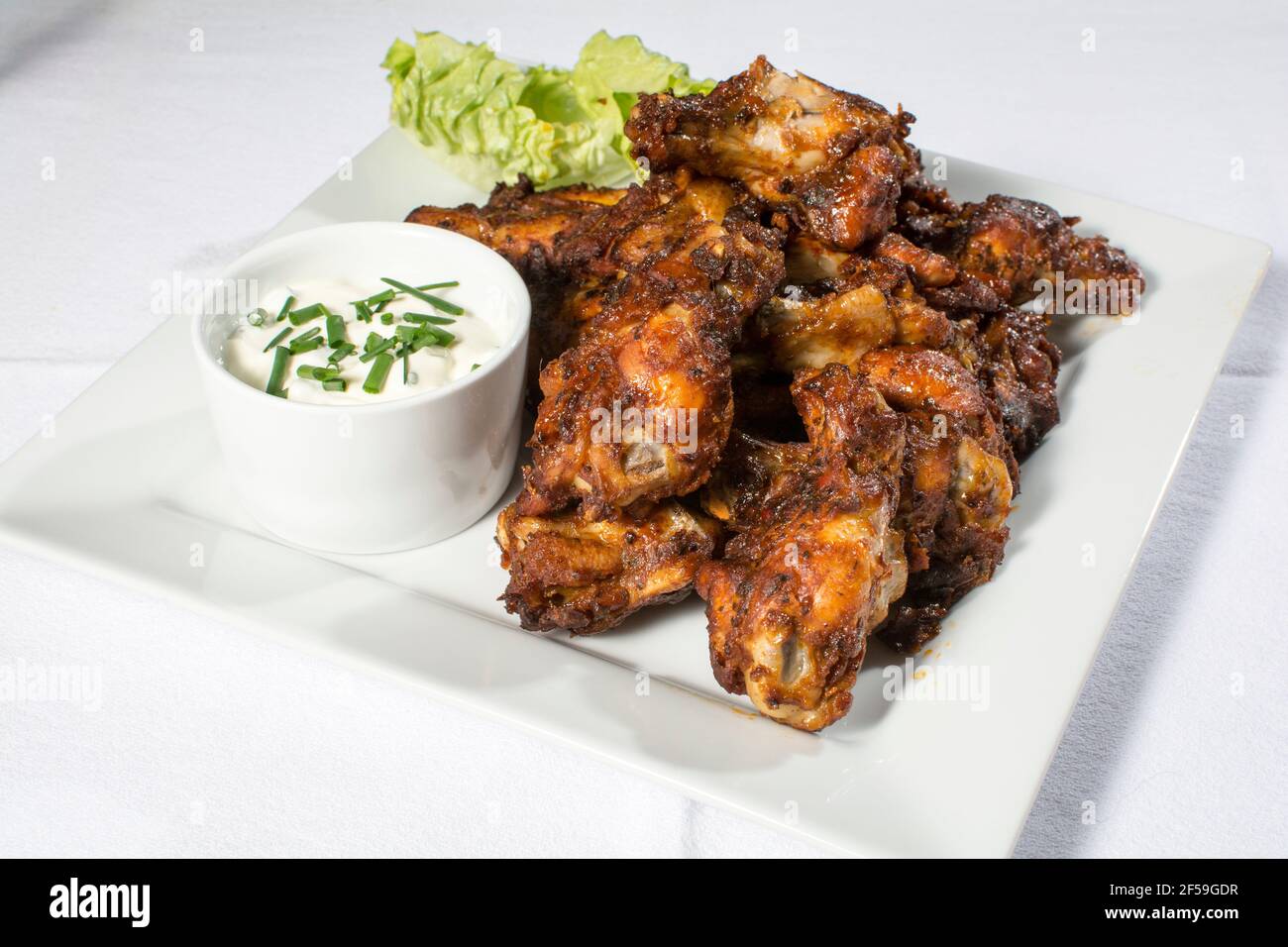 A plate of spicy BBQ chicken wings with dip Stock Photo
