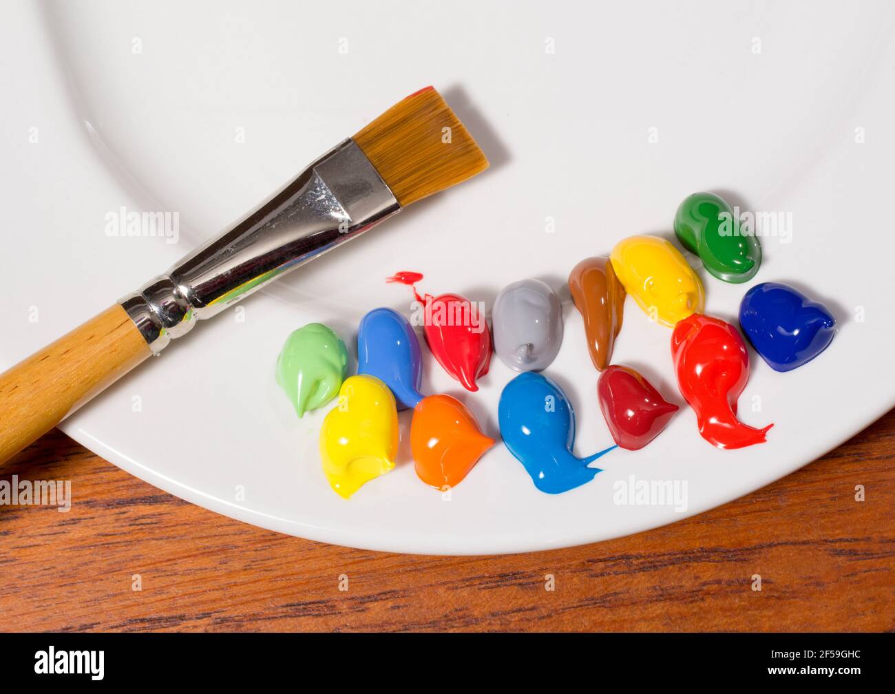 Paint palette on plate and glass containing brushes Stock Photo - Alamy