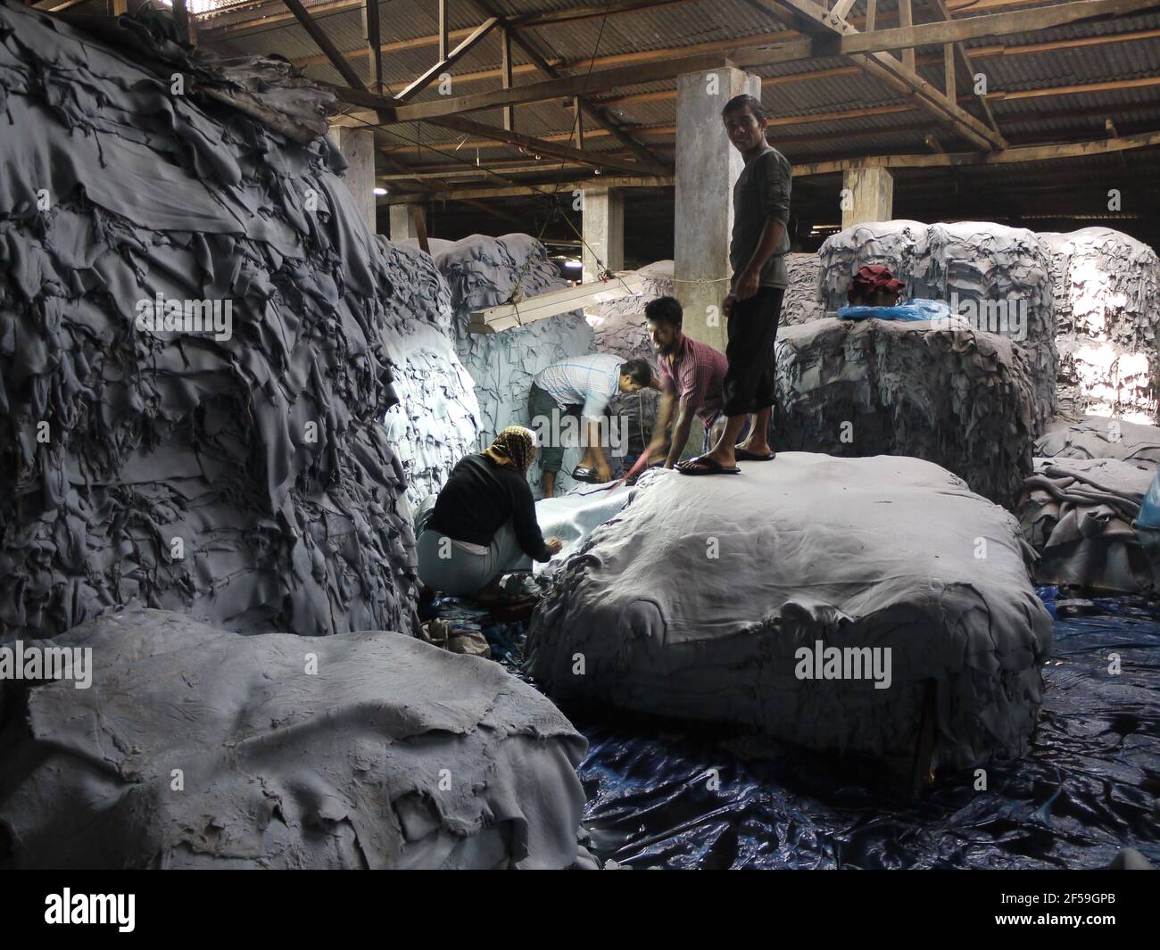 Workers inside a tannery in district of Hazaribagh, Dhaka, Bangladesh, where skin are washed to produce leather Stock Photo