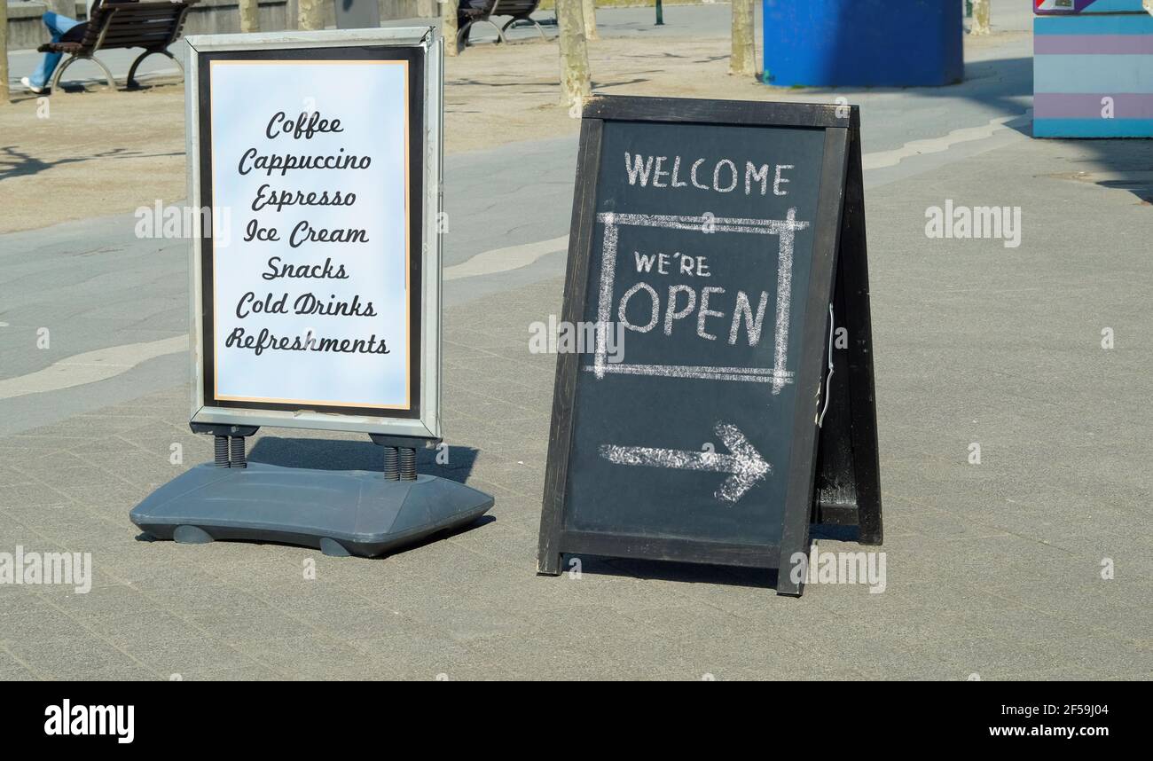 open sign, restaurant or cafe ready to service after corona lockdown, billboard with menu, food and drink, sandwich board in a city street Stock Photo