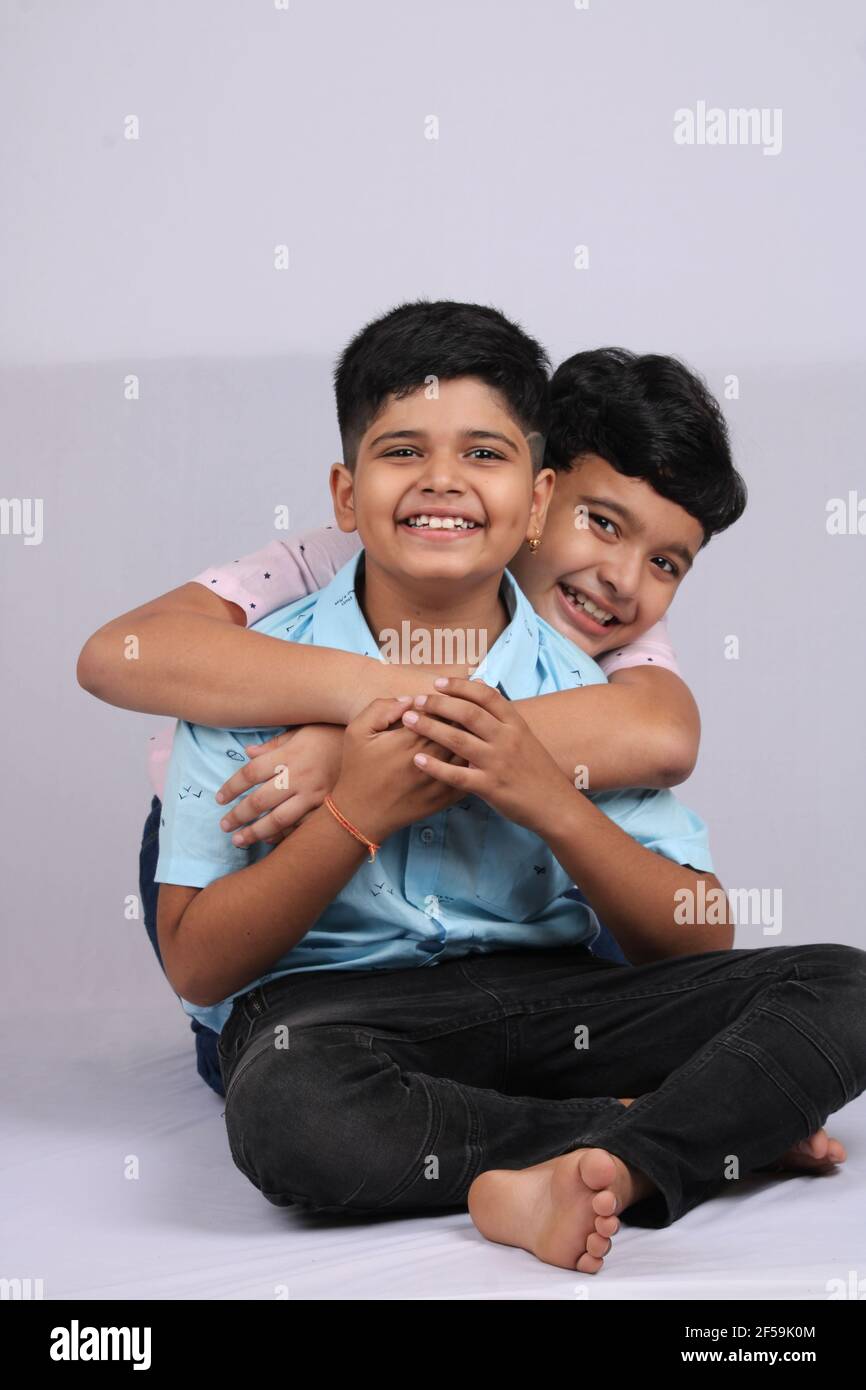 cheerful indian siblings hugging and posing for a photo. Stock Photo
