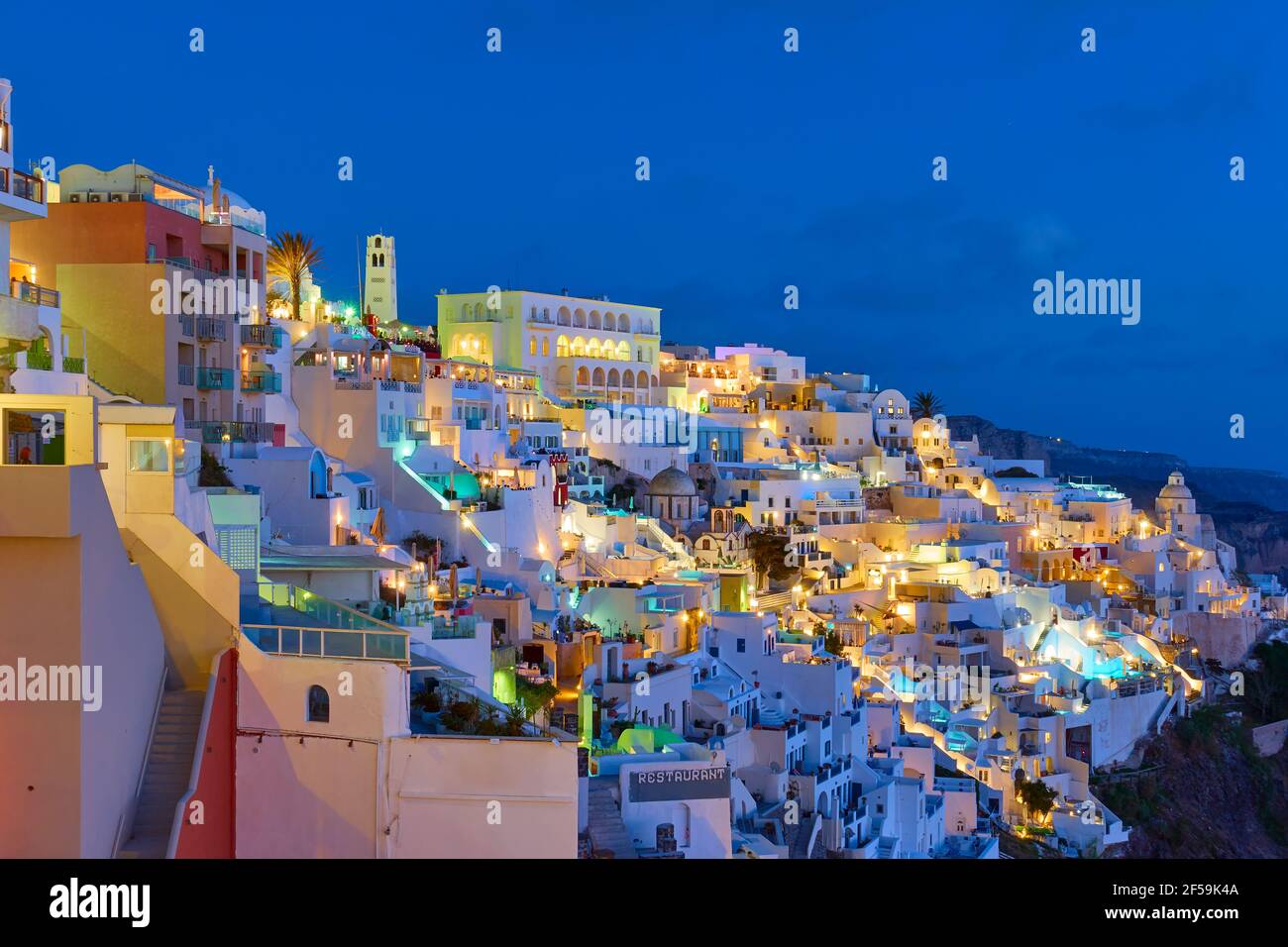 Santorini at night, Greece. Landscape with Fira town at dusk, panoramic view Stock Photo