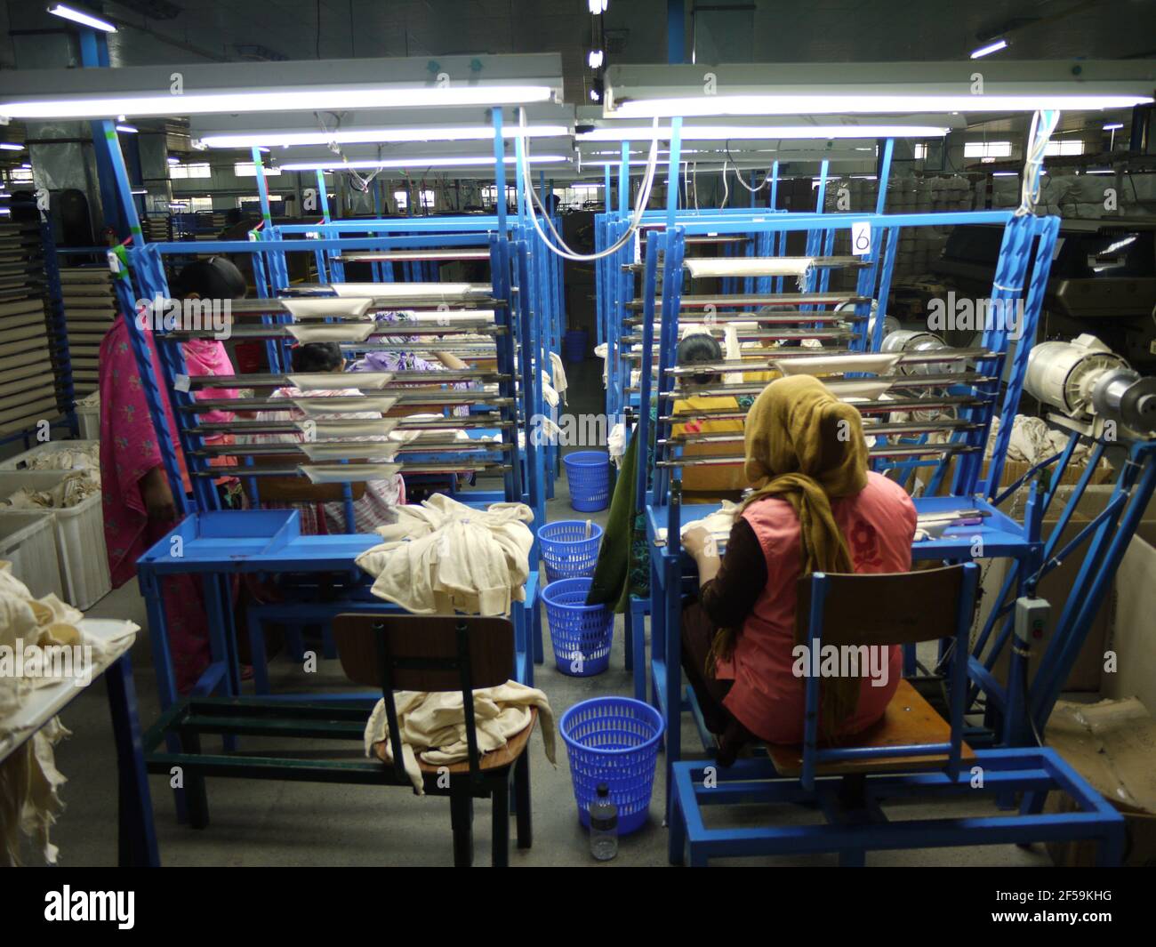 Workers of garment sector on a knitting machine in Bangladesh inside a factory in Dhaka Stock Photo