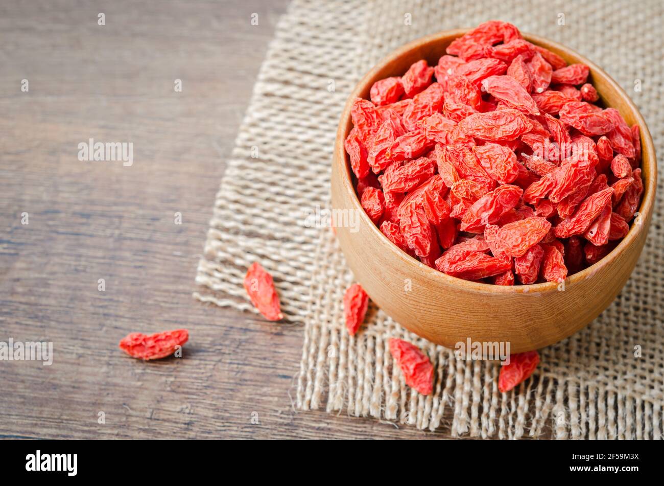 Dried Chinese wolfberries or goji berries in wooden cup. Stock Photo