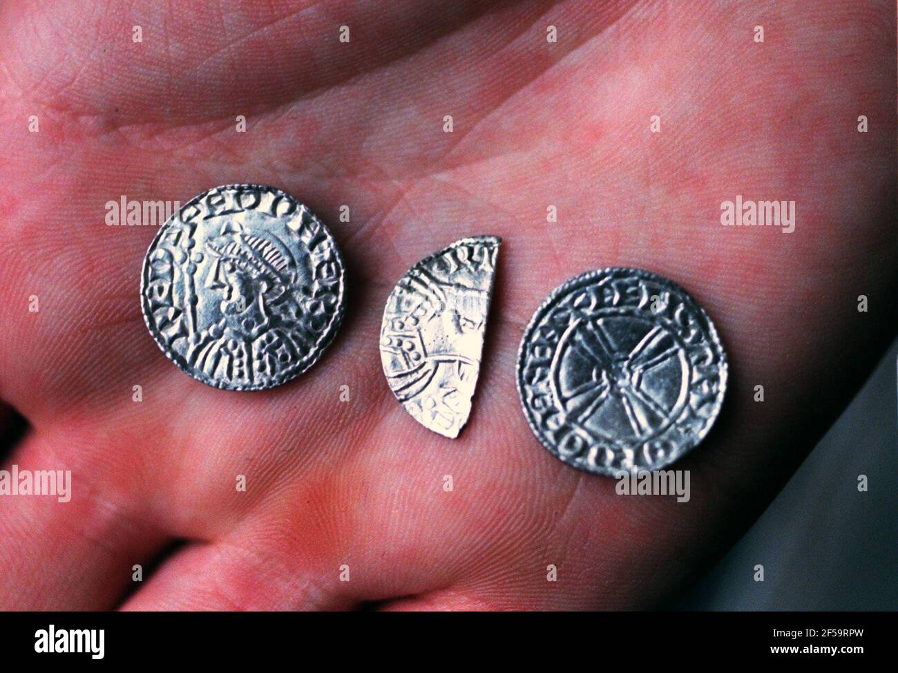 BRITISH MUSEUM TODAY PUT ON DISPLAY  A FIND OF SILVER PENNIES WHICH WERE IN CIRCULATION AT THE TIME OF EDWARD THE CONFESSOR  ABOUT 1050 AND FOUND BURIED IN APPLEDORE IN KENT IN 1997  PICTURE SHOWS A TYPICAL FACE AND REVERSE SIDE ,AND A COIN THAT HAS BEEN CUT IN HALF  WHICH WAS A LEGAL METHOD OF DIVIDING THE COIN TO GIVE TWO HALFS OF EQUAL VALUE AND HALF THE VALUE OF THE ORIGINAL COIN Stock Photo