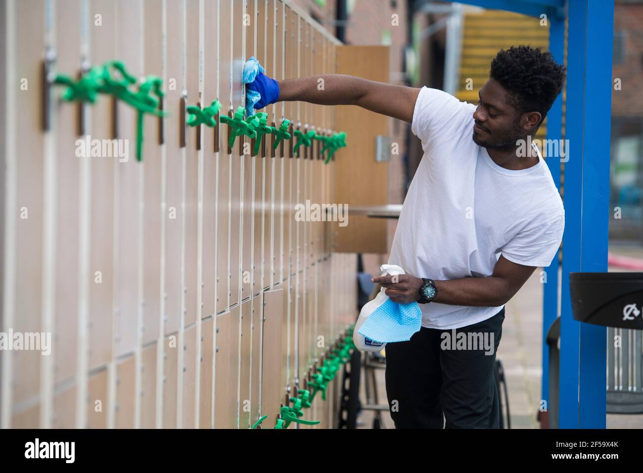 A member of staff cleans lockers during preopening preparation and