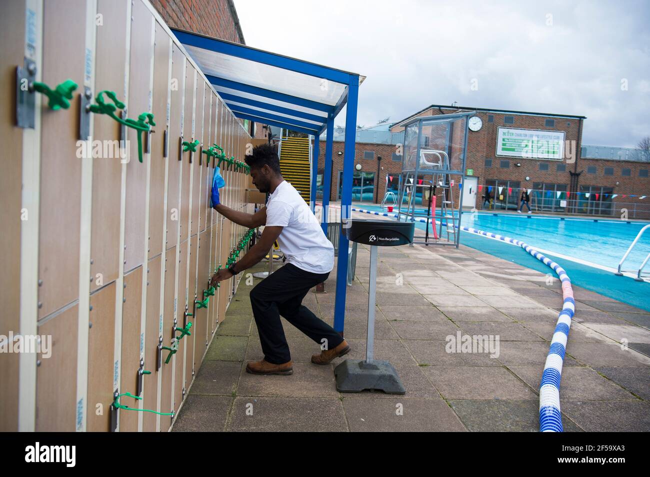 A member of staff cleans lockers during preopening preparation and