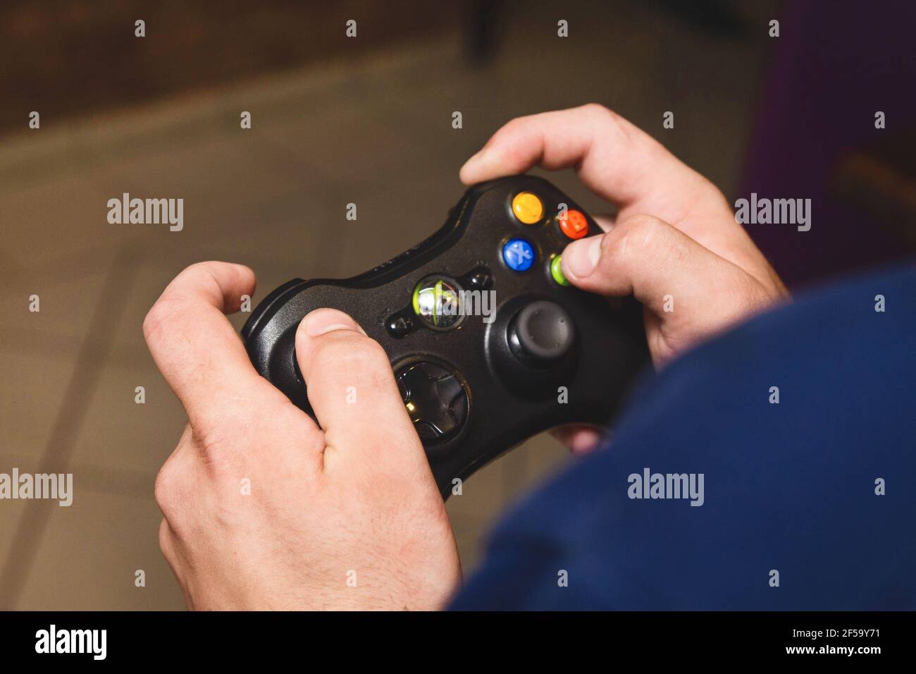 Belarus, Minsk region - August 27, 2017: The guy's hands are holding a joystick xbox and playing a console, close-up. Stock Photo