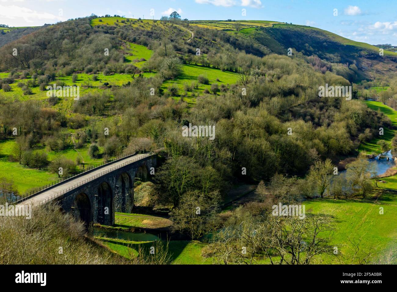 Early spring sunshine at Monsal Head a popular viewpoint in the Peak District National Park Derbyshire England UK with Monsal Viaduct in foreground. Stock Photo