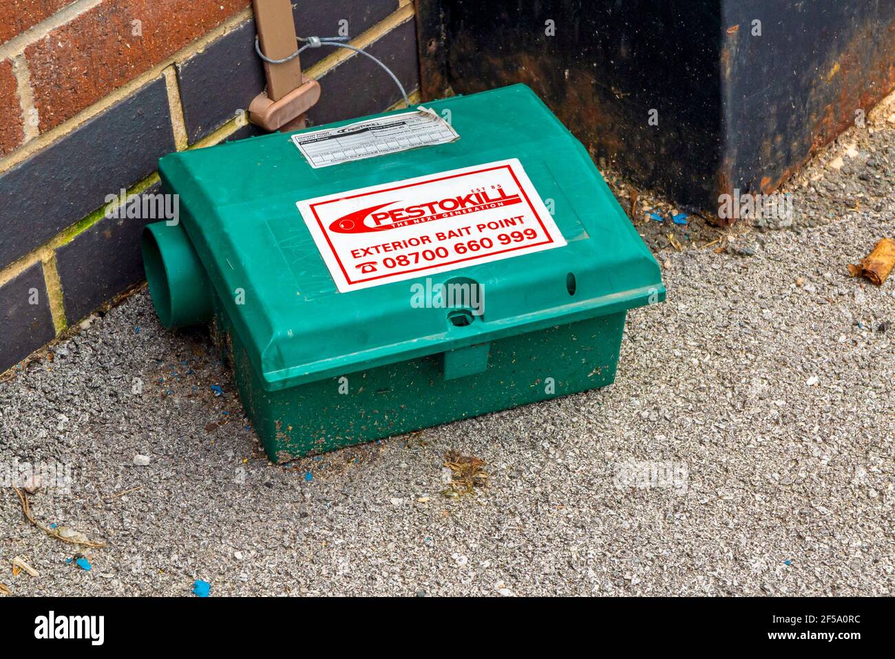Plastic exterior bait point container used to poison rats outside a shop supplied by Pestokill a UK company providing pest control services. Stock Photo