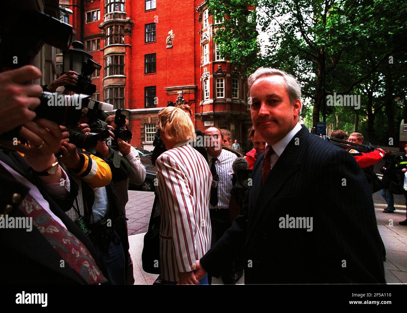 Neil Hamilton former MP for Tatton with his wife Christine near the Millbank media centre Westminster after hearing the findings of the Downey report into the cash for questions scandal Stock Photo