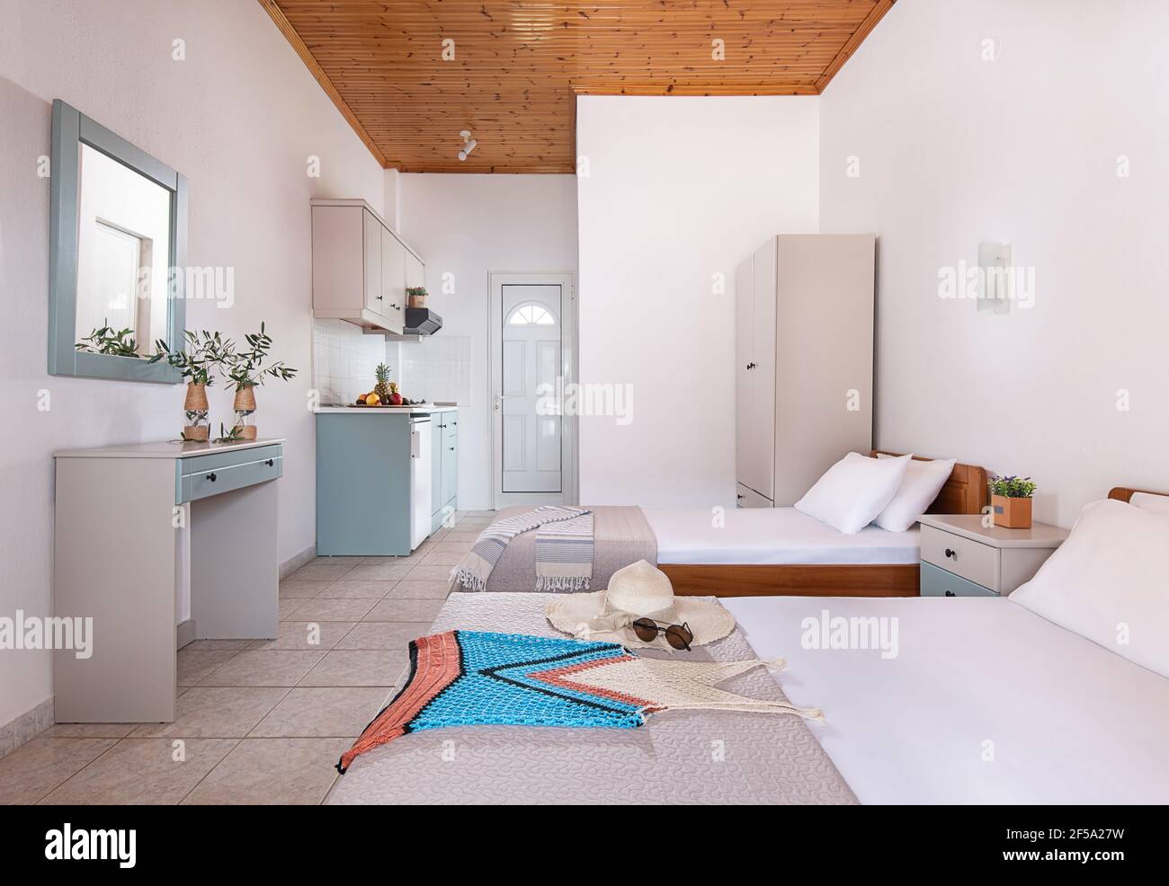 Classic style white interior of double hotel bedroom, bathroom, kitchen  cabinets module in single space of modern small studio apartment flat with  sin Stock Photo - Alamy