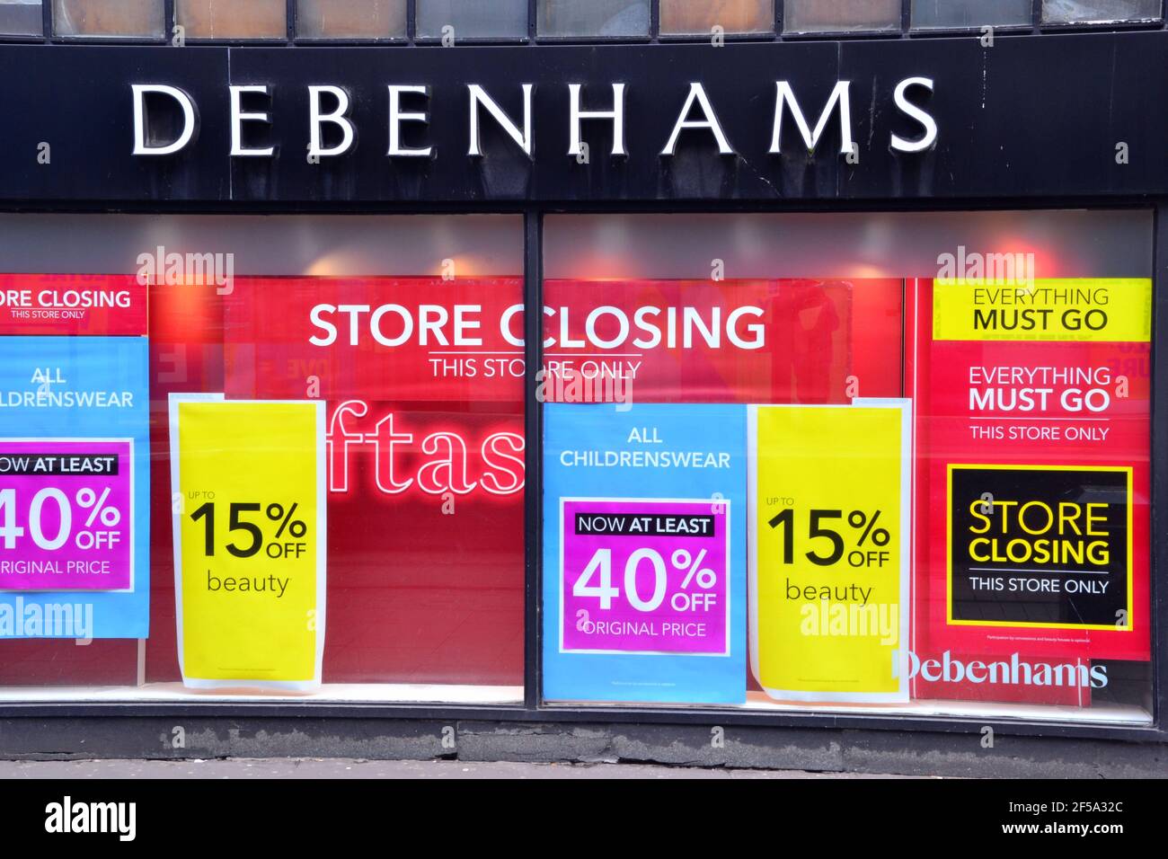 A window of a Debenhams store in Manchester, Greater Manchester, England, United Kingdom, which displays 'store closing', 'everything must go' posters Stock Photo