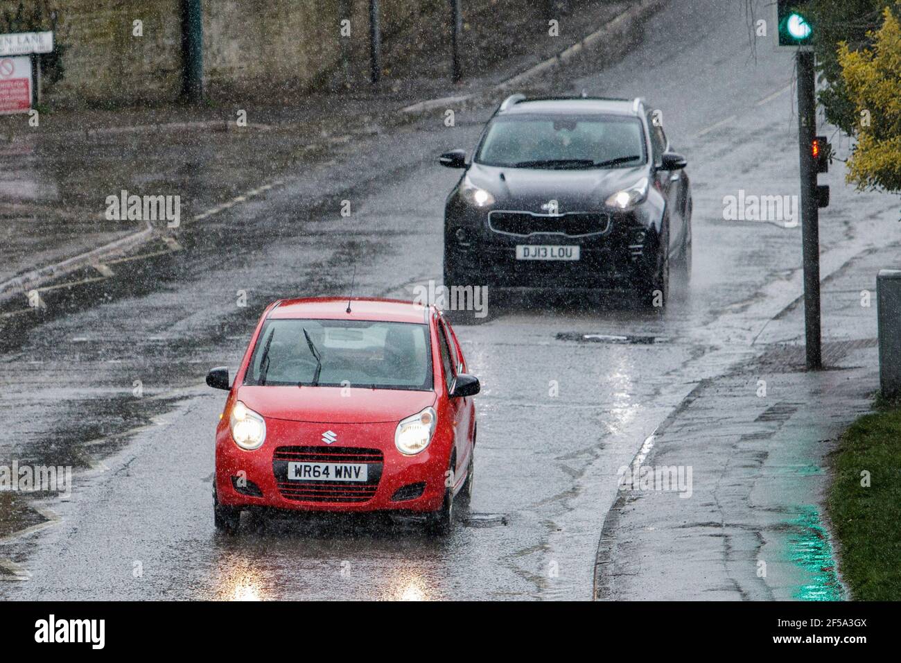 Chippenham, Wiltshire, UK, 25th March, 2021. Car drivers are pictured driving in heavy rain in Chippenham as heavy rain showers make their way across Southern England. Credit: Lynchpics/Alamy Live News Stock Photo