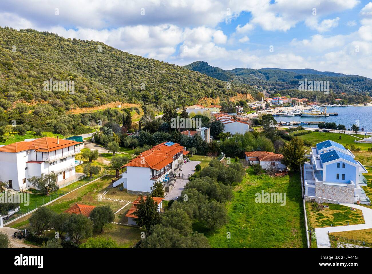 Drone top view from above to European resort village with apartment hotels by lake landscape. Aerial panorama of white residential houses among summer Stock Photo