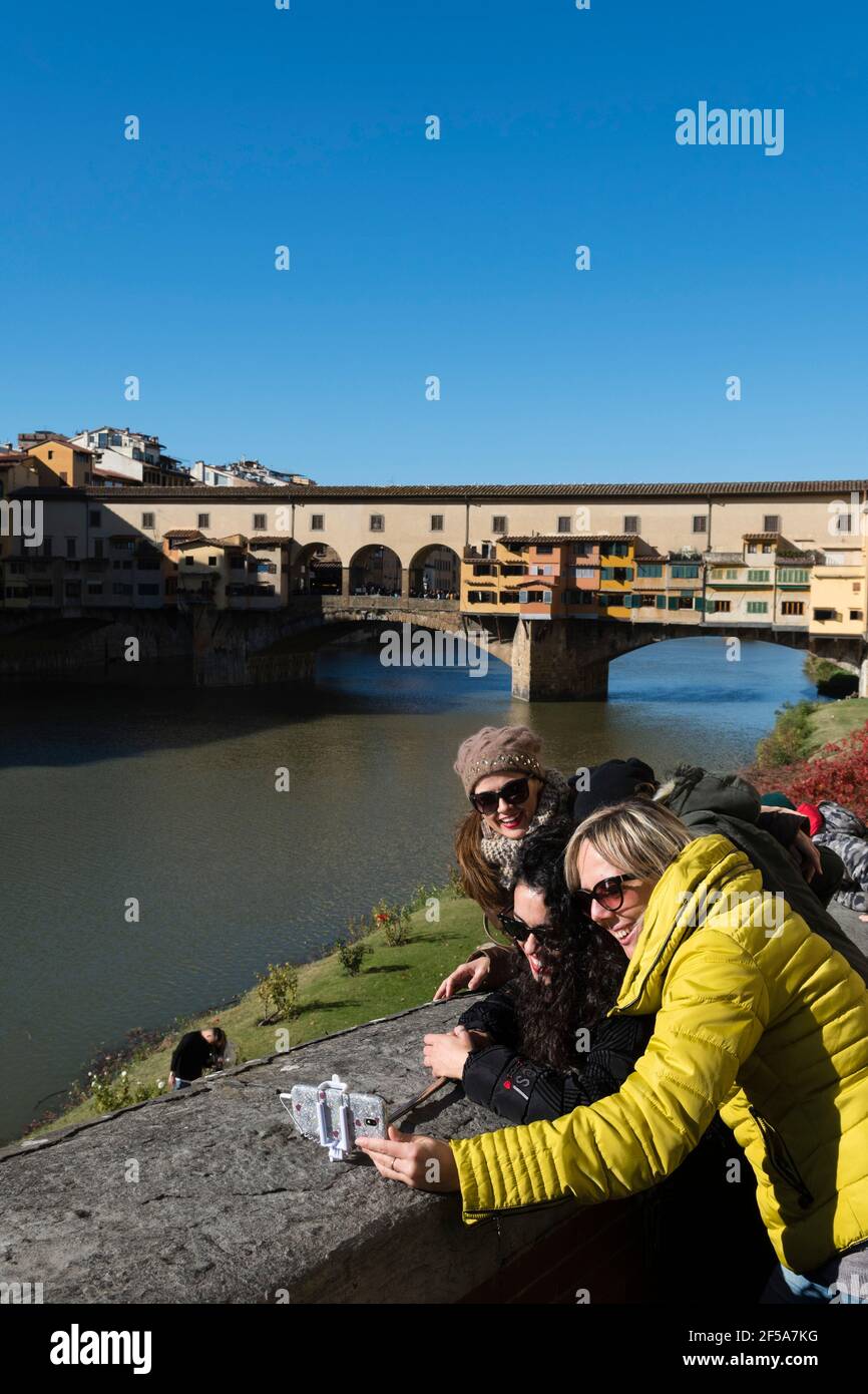 Tourist making a selfie on Lungarno degli Archibusieri street with Ponte Vechio in the background, Florence, Tuscany, Italy. Stock Photo