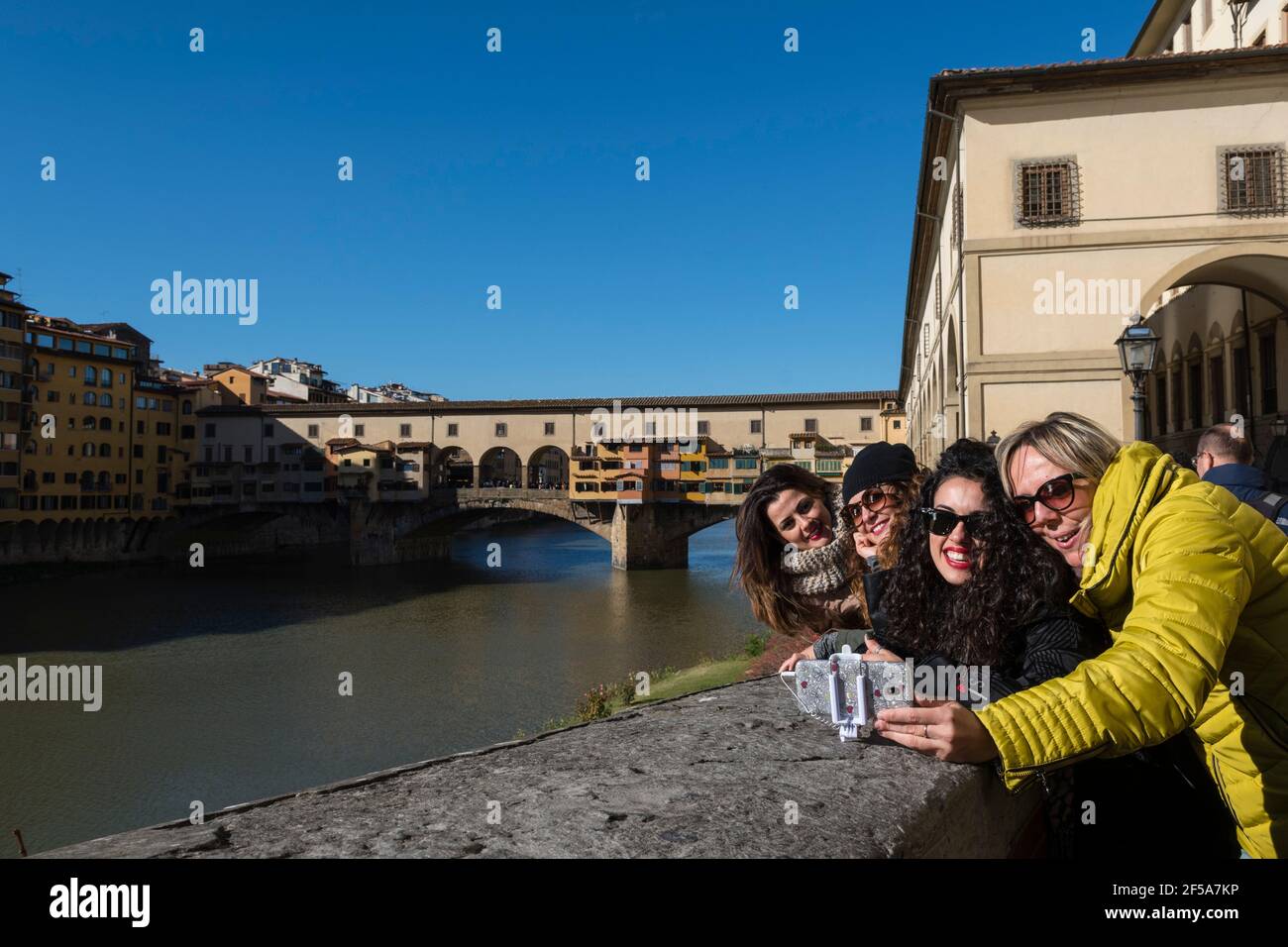 Tourist making a selfie on Lungarno degli Archibusieri street with Ponte Vechio in the background, Florence, Tuscany, Italy. Stock Photo