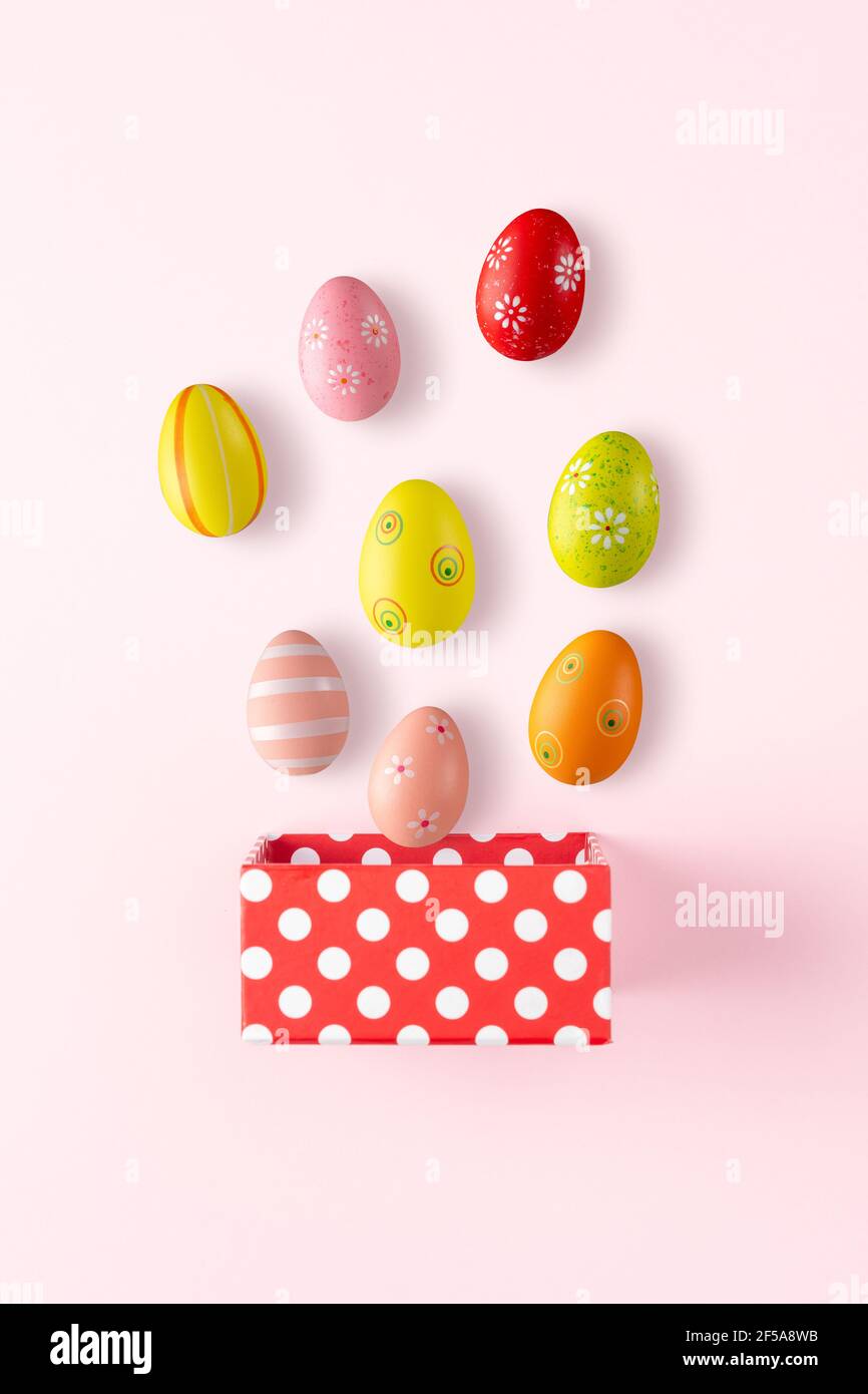 Gift box with Easter eggs on bright background. Minimal spring holiday concept. Stock Photo