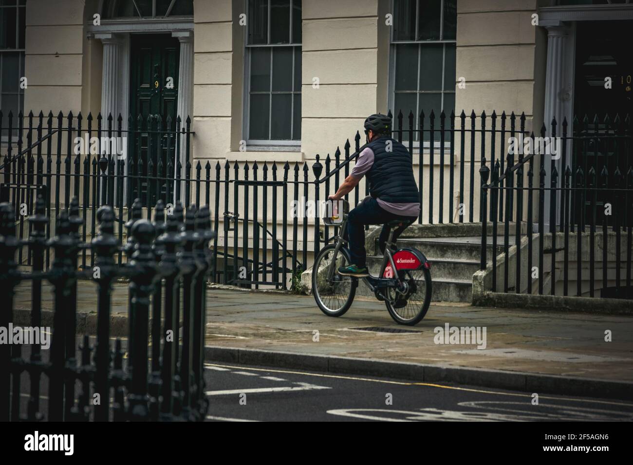Man riding a hired bicycle in London. Stock Photo