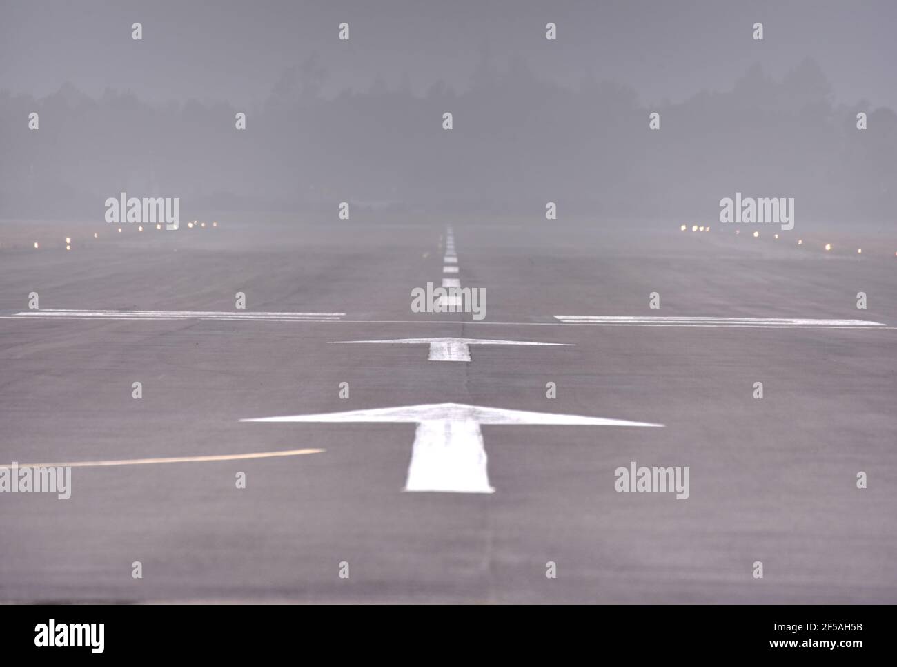 Arrows point along a misty runway at Blackbushe airfield on Yateley Common in Hampshire Stock Photo
