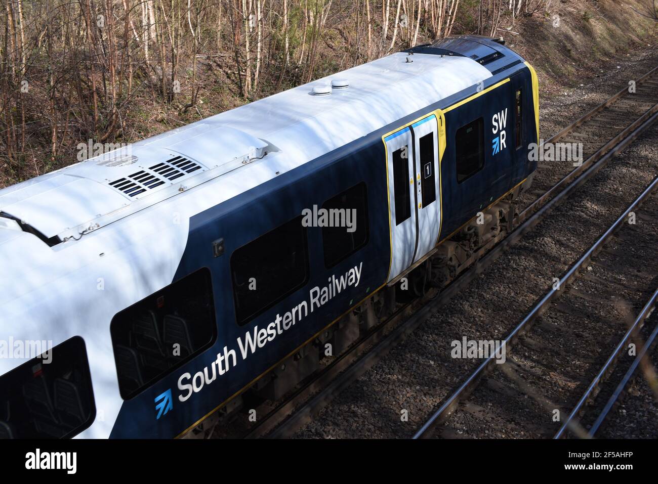 A train leaves Ash Vale station in Surrey in this photo taken on a bright March day Stock Photo