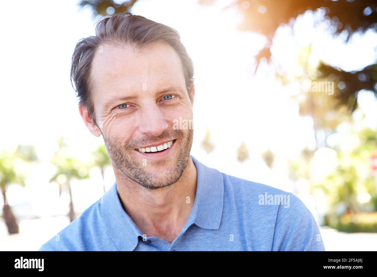 Close up portrait of handsome middle age man smiling outdoors Stock Photo