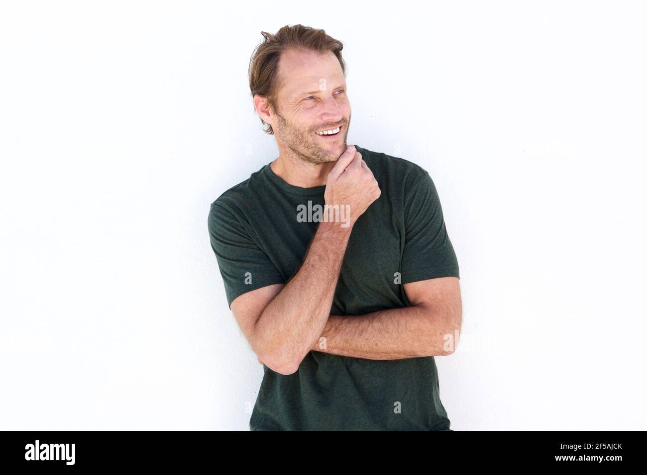 Portrait of happy man smiling against white wall Stock Photo - Alamy