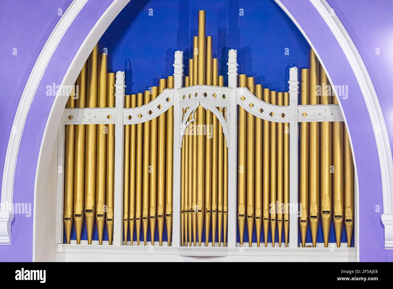 Gold painted pipes on a small church organ. Stock Photo