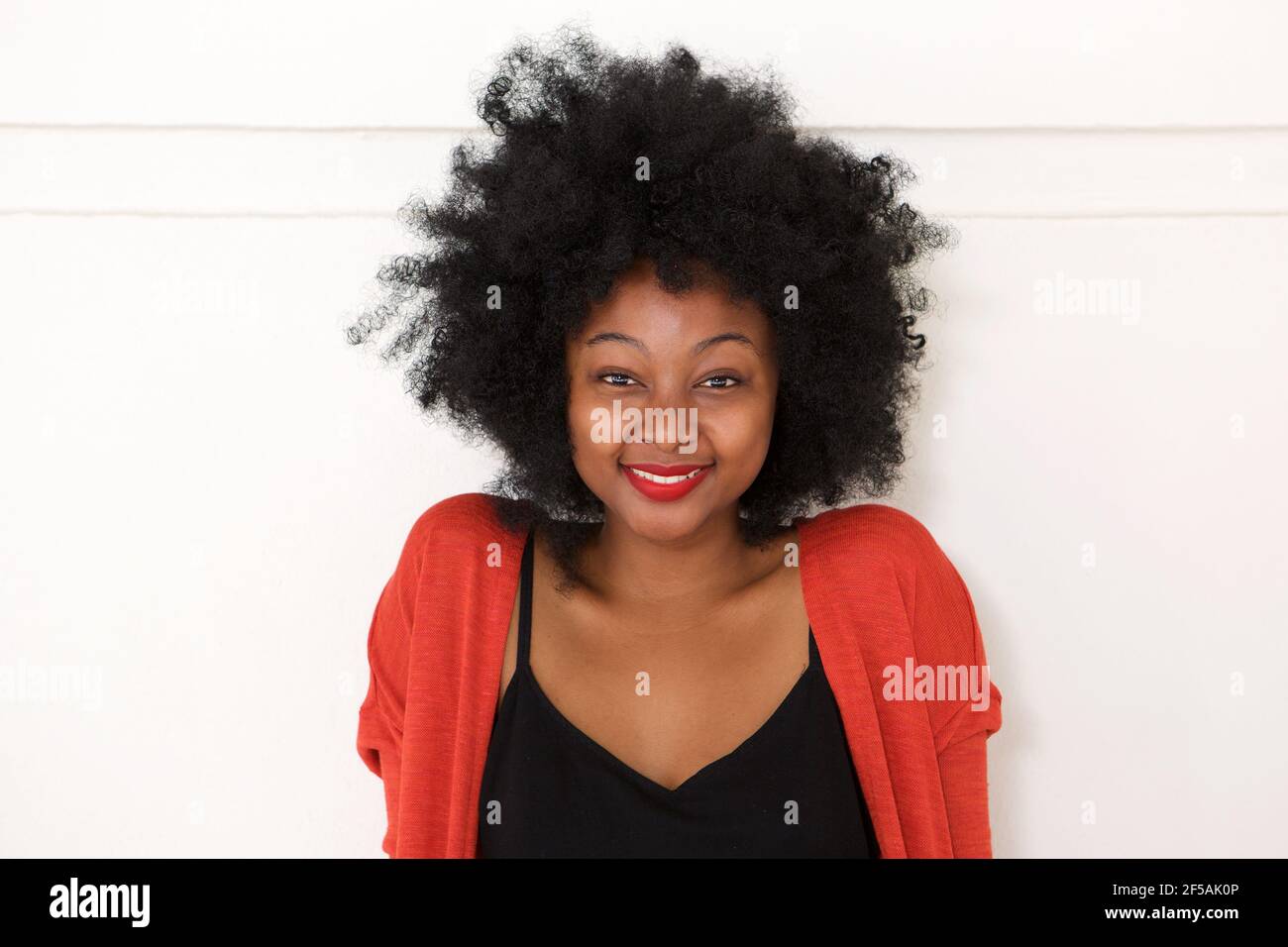 Close up portrait of young african woman smiling by white wall Stock ...
