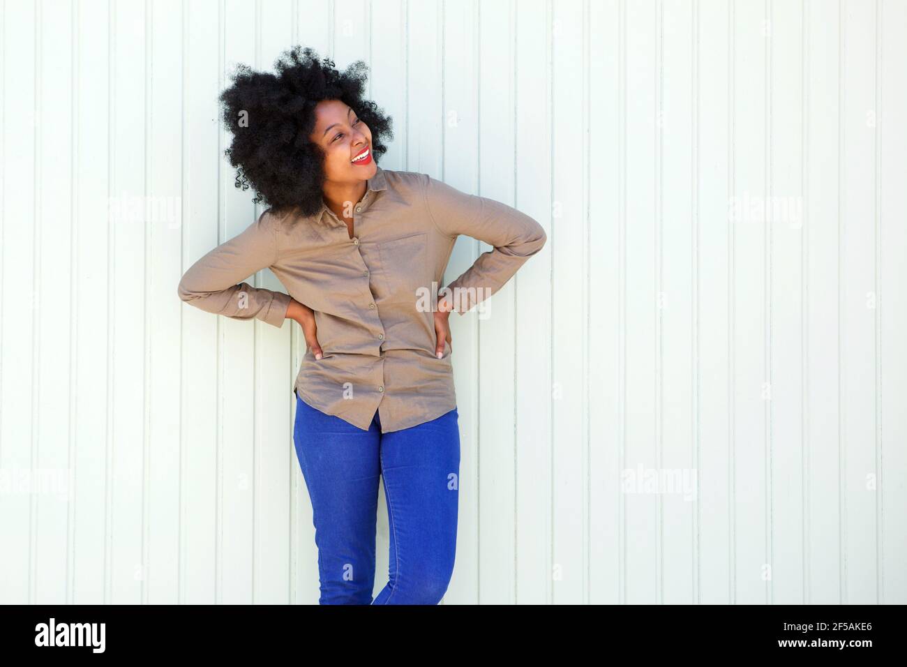 Portrait of beautiful woman smiling by white wall Stock Photo - Alamy