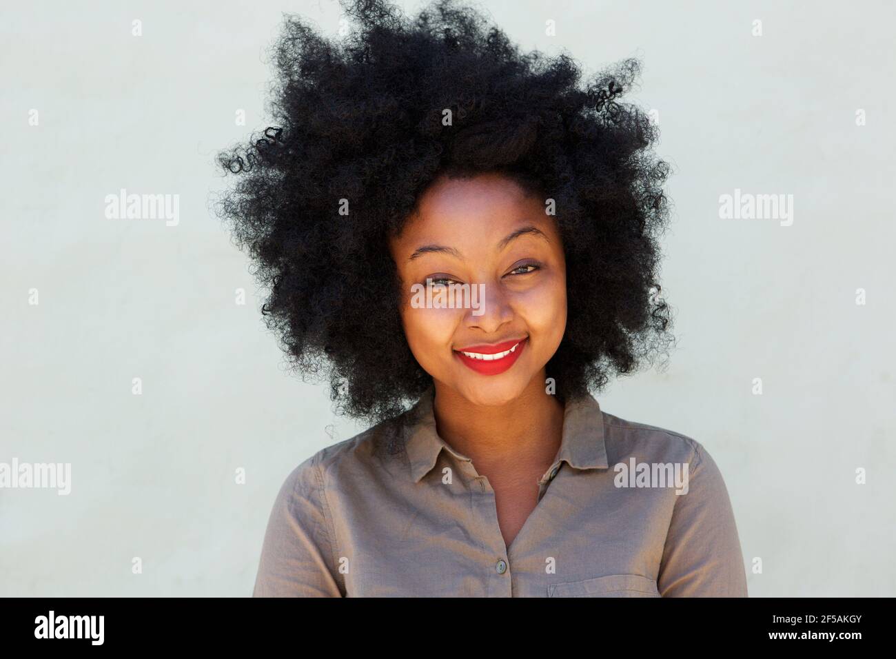 Close up portrait of beautiful smiling woman by white wall Stock Photo ...