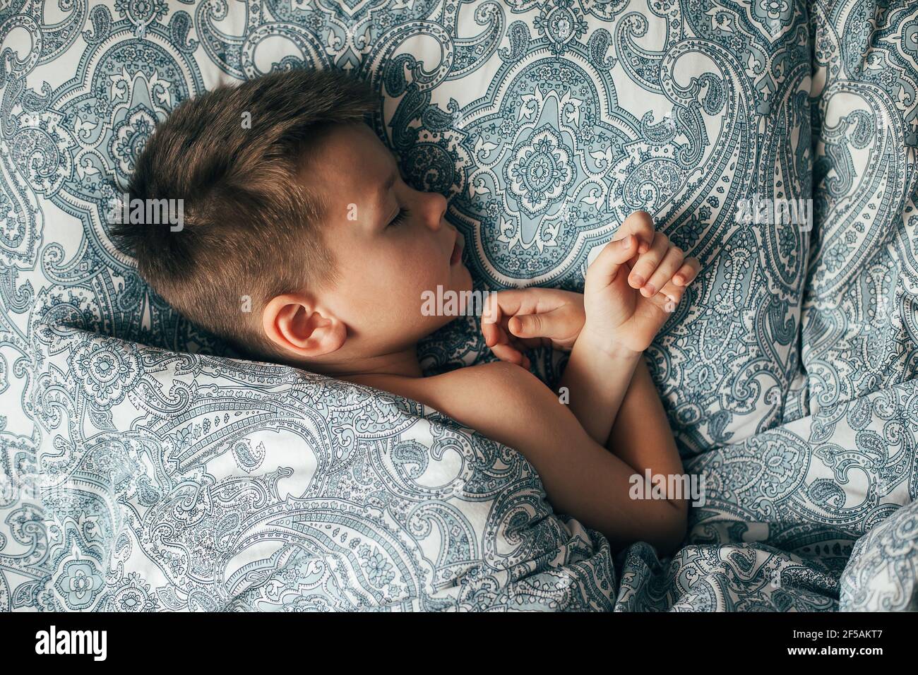 Adorable boy 67 years old sleeping in bed. Child having a good dreams