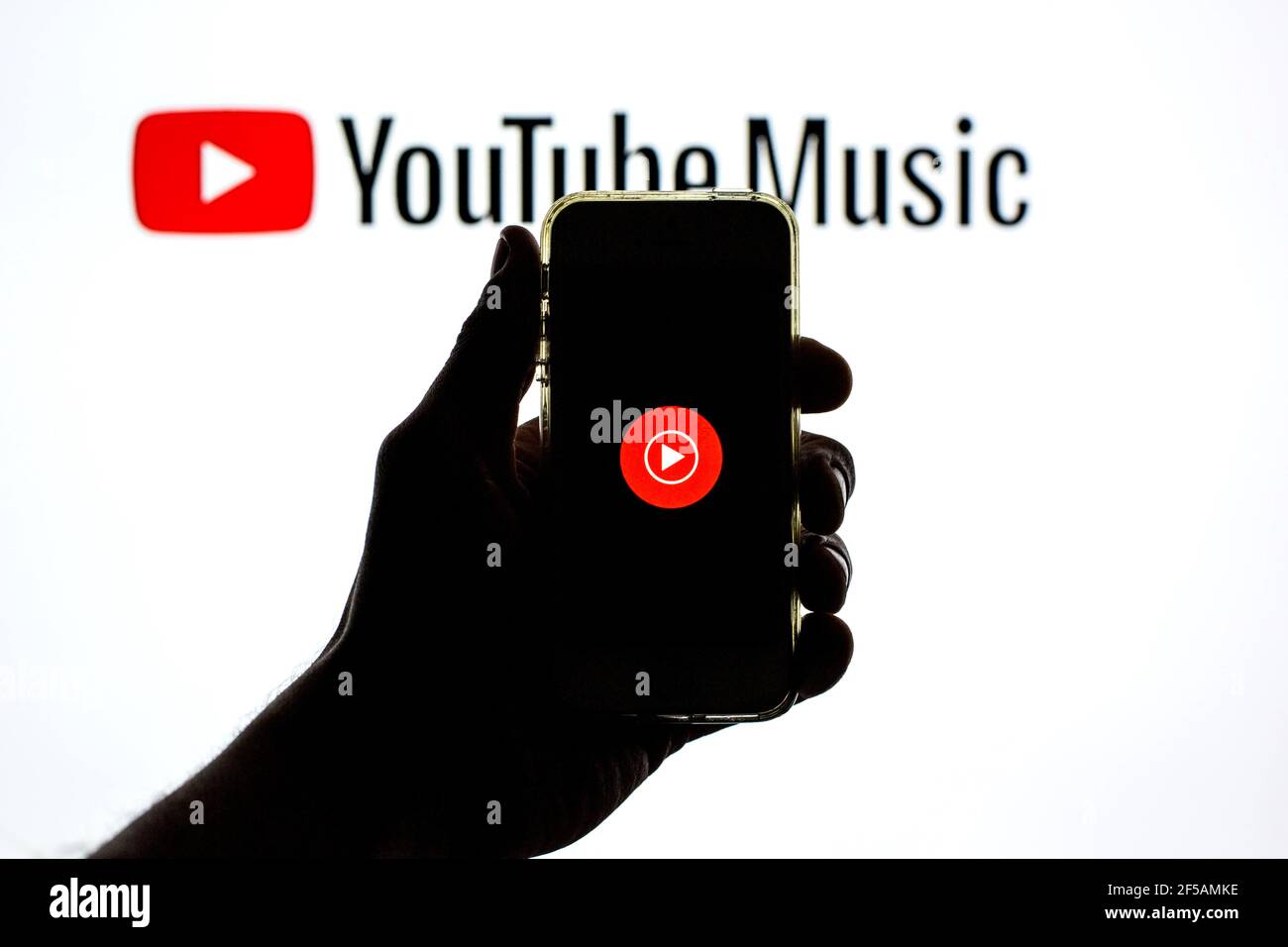 In this photo illustration the YouTube Music app seen displayed on a  smartphone screen and a YouTube Music logo in the background Stock Photo -  Alamy
