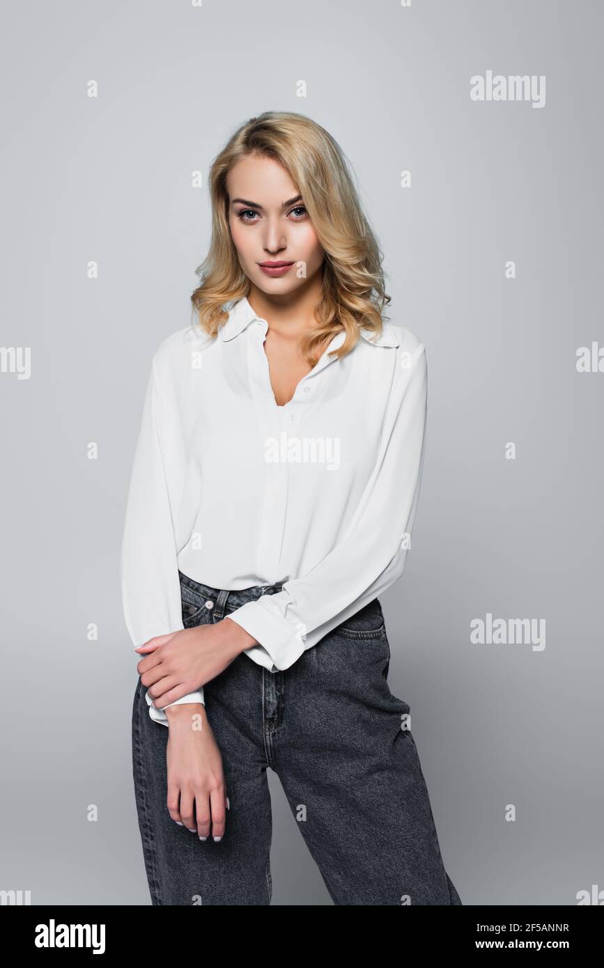 blonde woman in white shirt looking at camera on grey Stock Photo - Alamy