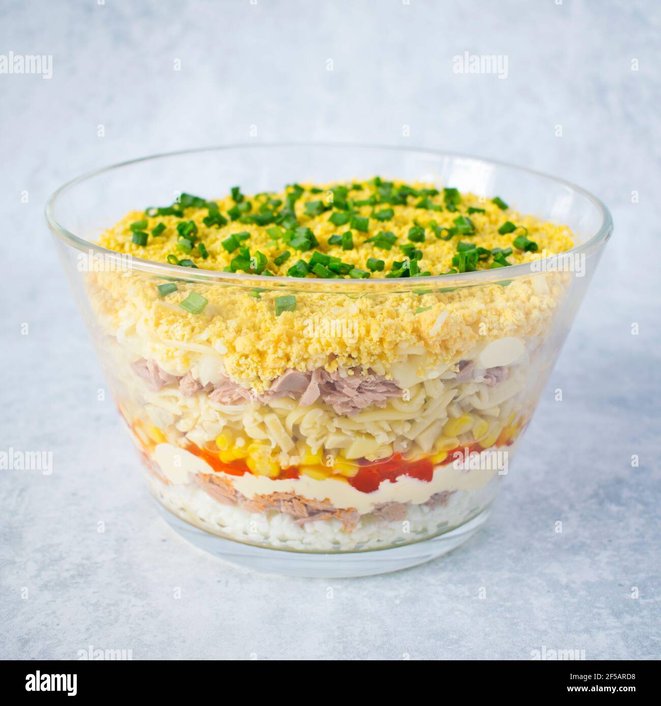 Layered salad with tuna, pickled peppers, mushrooms and cheese. Stock Photo