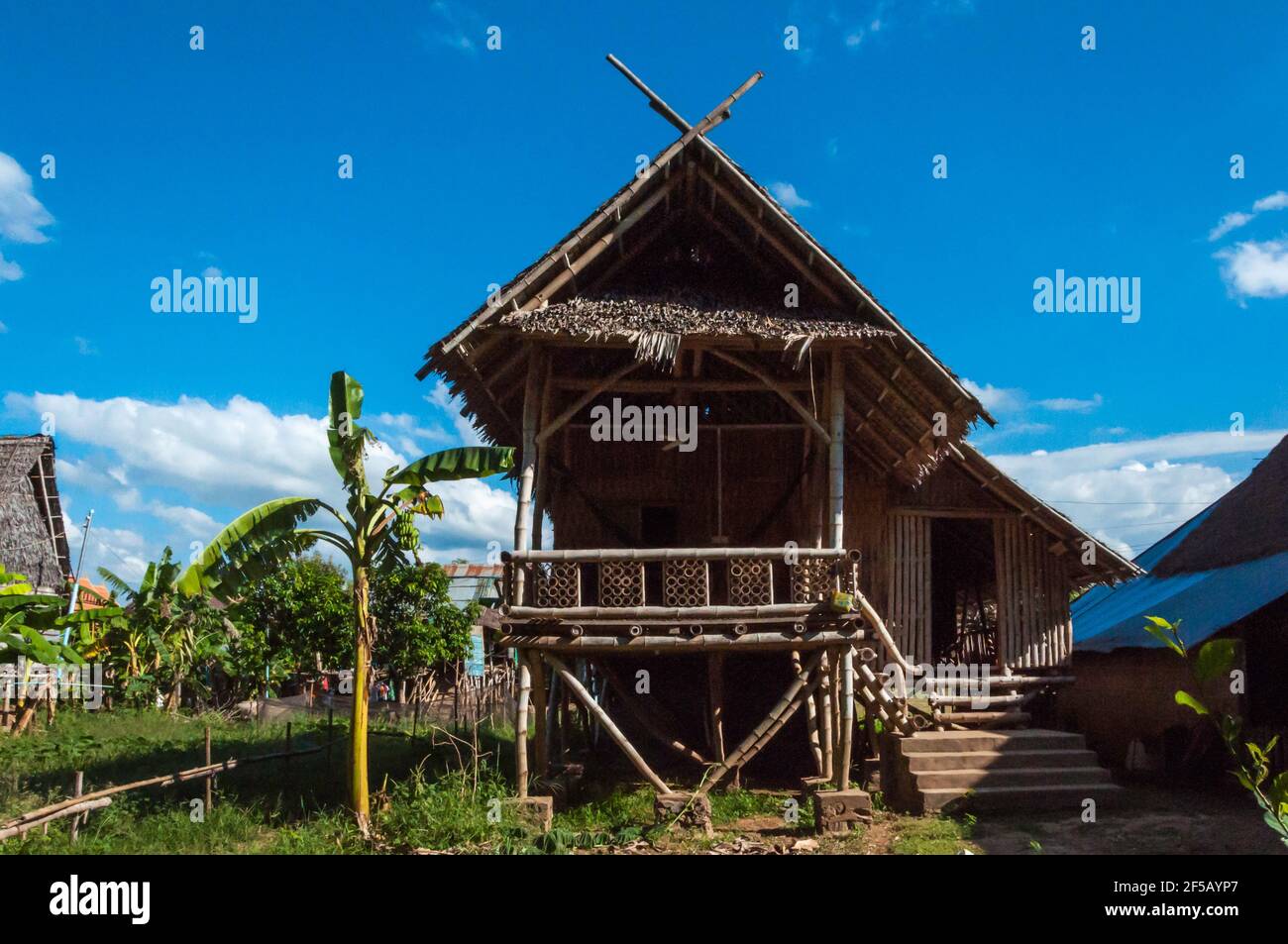 Wooden house in traditional pile construction, the roof is covered with palm leaves. Stock Photo