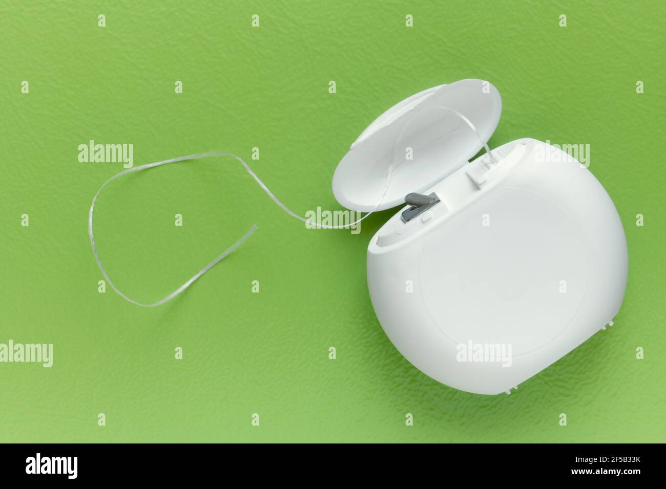 Dental floss on a green background with copy space, top view Stock Photo