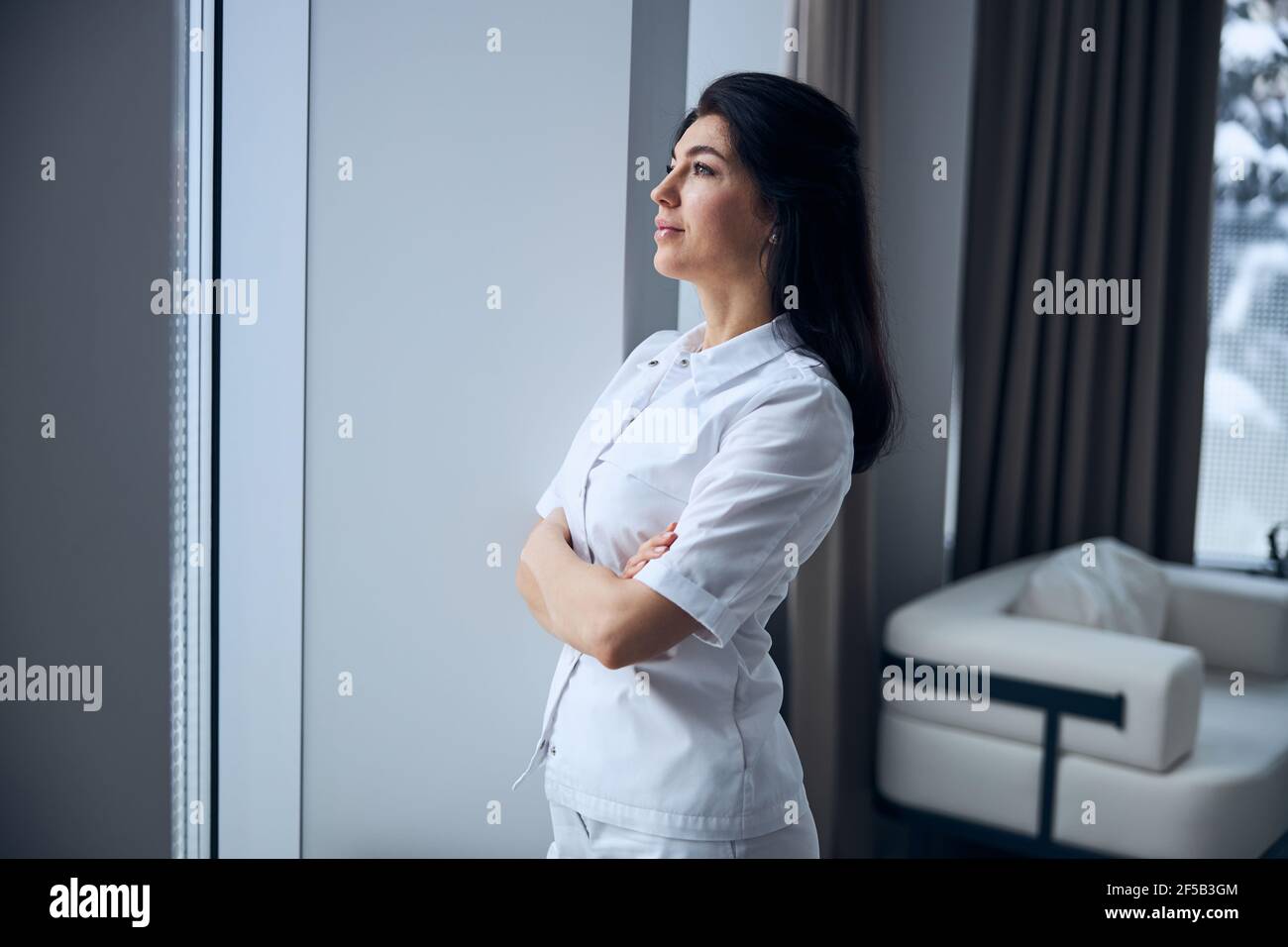 Pensive middle-aged physician waiting for a patient Stock Photo