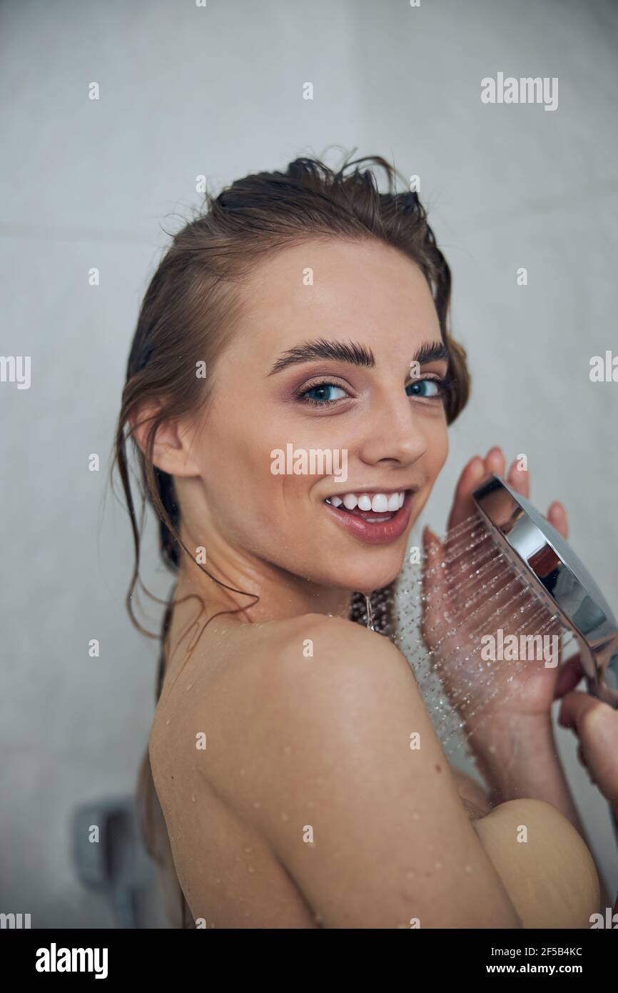 Joyous blonde Caucasian lady taking a shower Stock Photo - Alamy