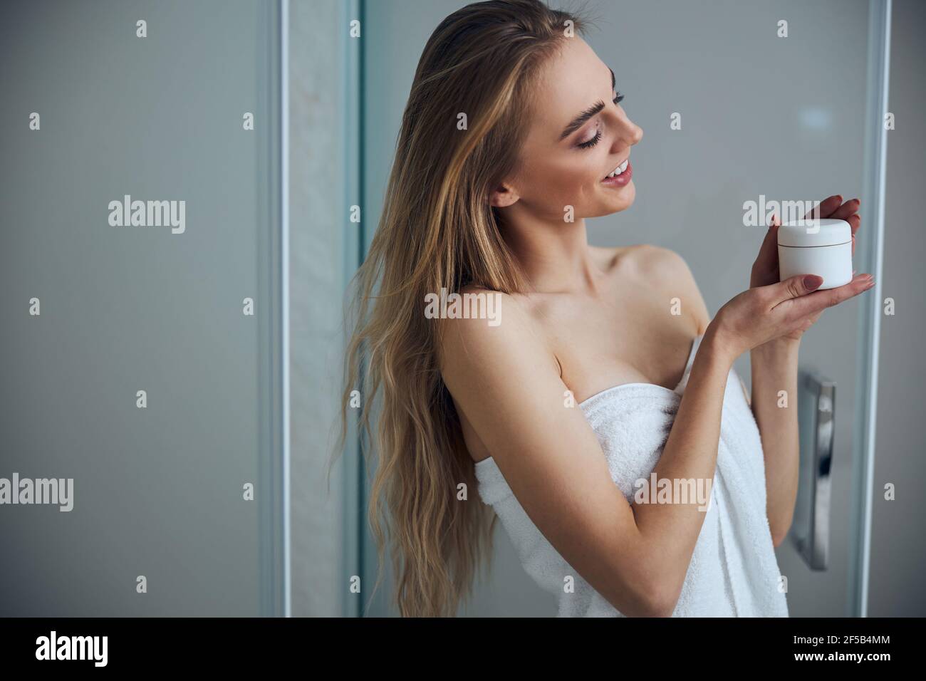 Pleased woman examining her new beauty product Stock Photo