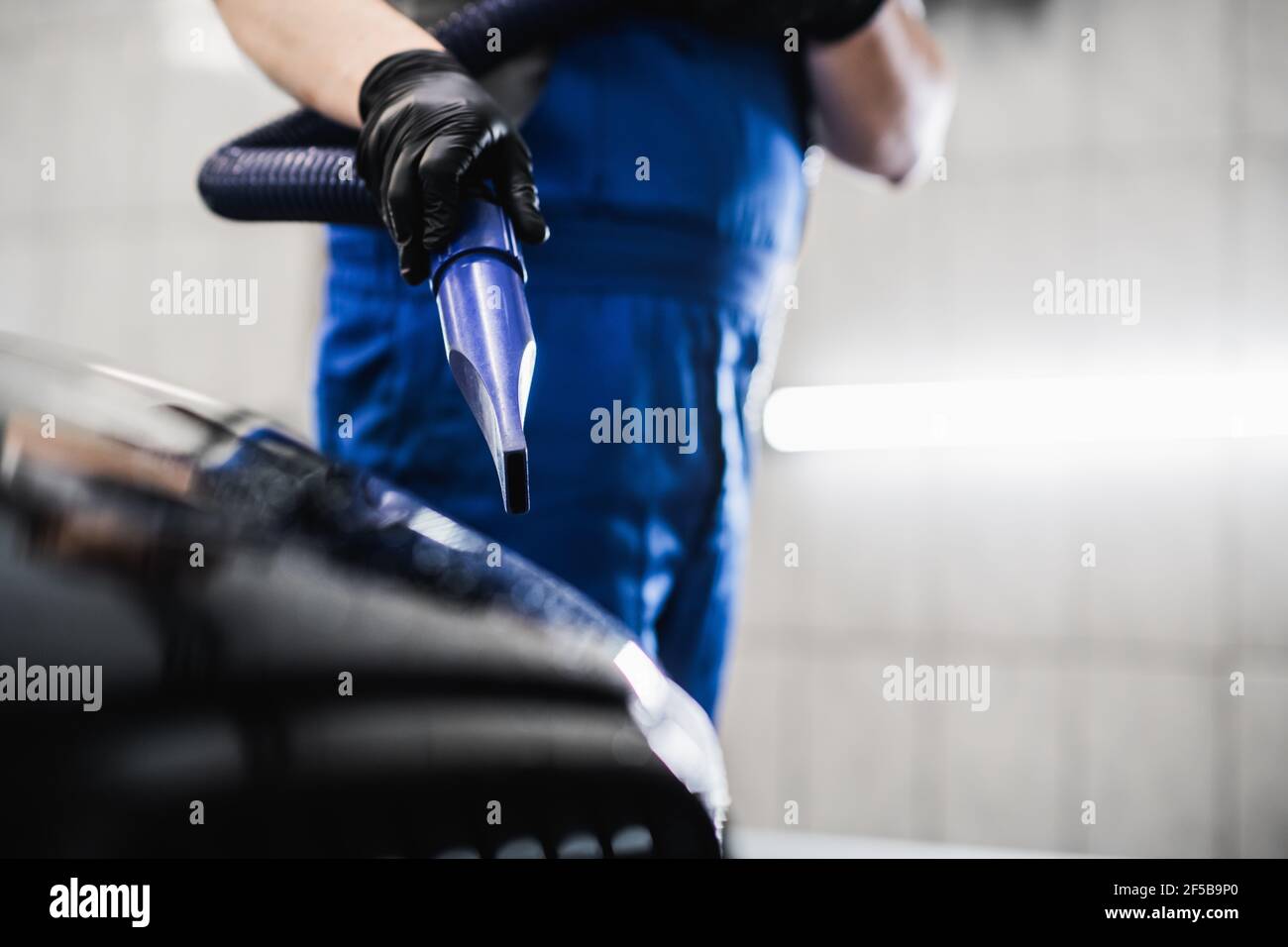 Man blowing off water from freshly washed black car with air. Car wash and  detailing service Stock Photo - Alamy
