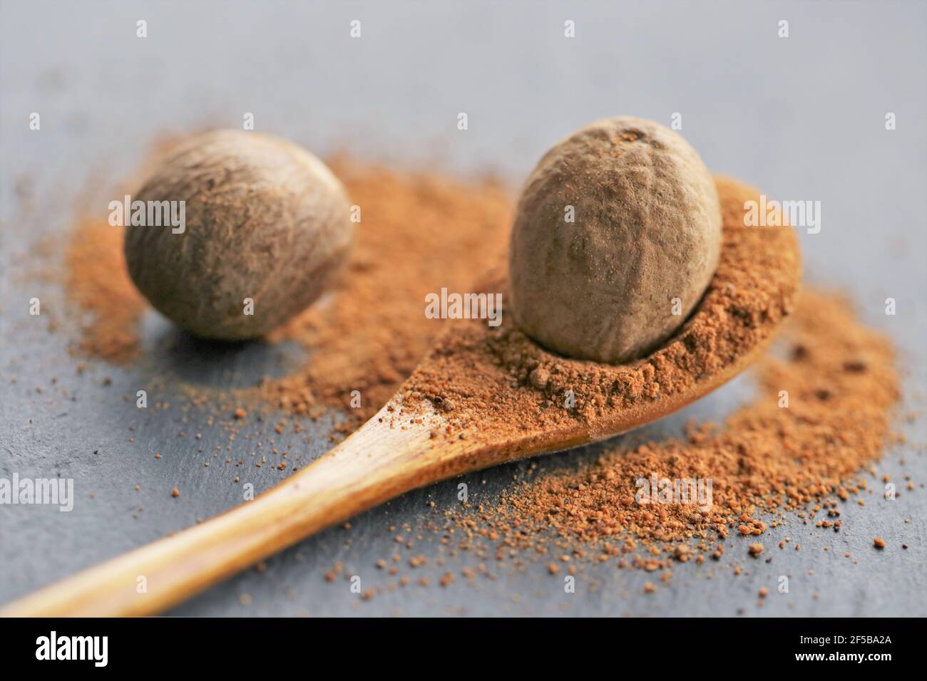 https://c8.alamy.com/comp/2F5BA2A/nutmeg-spicewhole-and-ground-nutmeg-in-a-wooden-spoon-close-up-on-a-schiffer-backgroundspices-and-herbs-conceptfood-ingredientspices-for-meat-2F5BA2A.jpg
