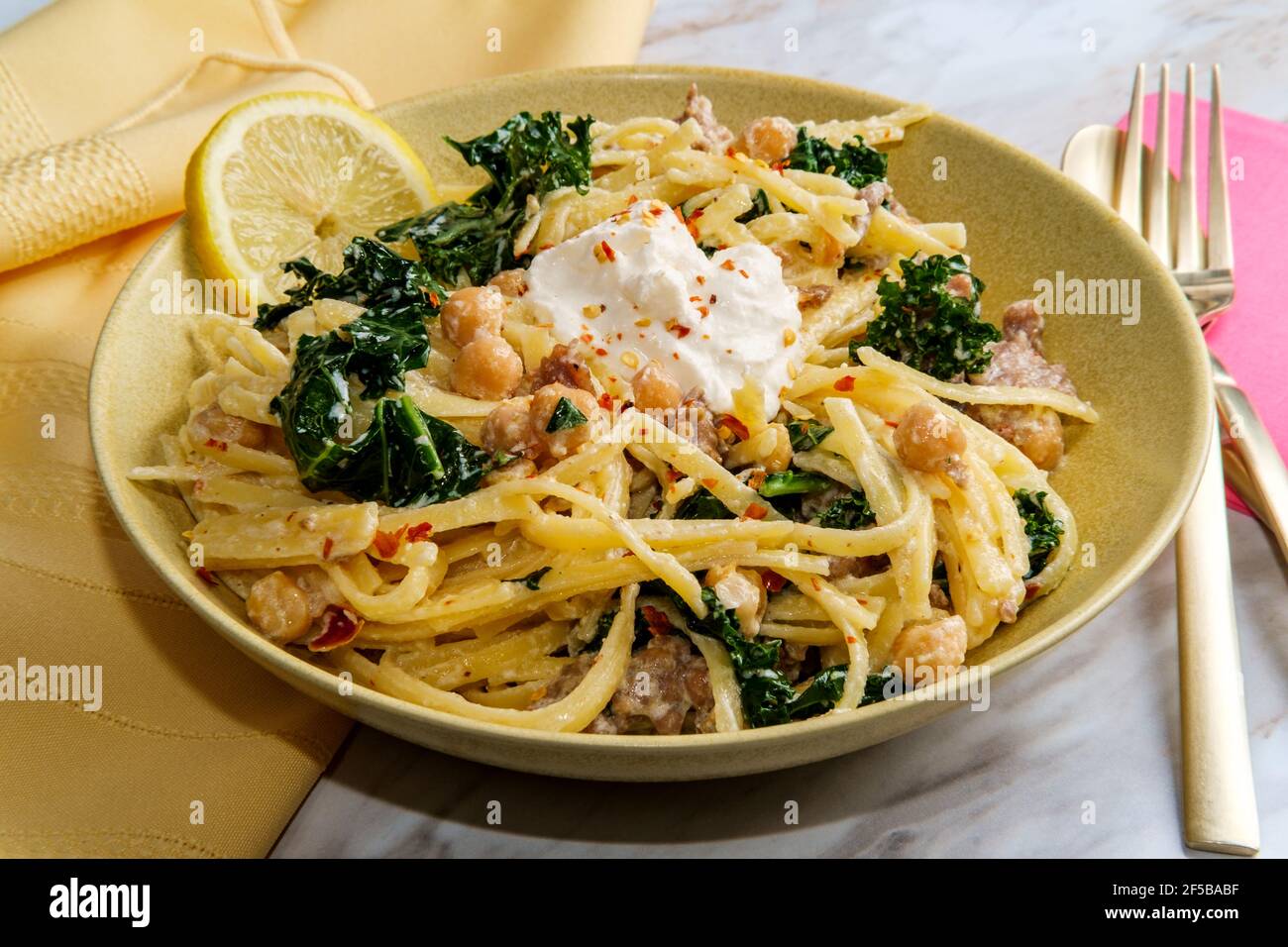 Linguine pasta with Italian sausage chickpeas and kale in a creamy