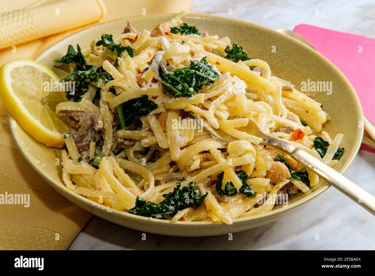 Linguine pasta with Italian sausage chickpeas and kale in a creamy