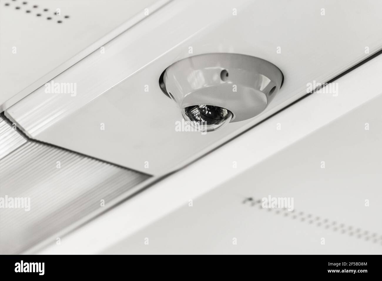 Surveillance camera on the white ceiling background of a modern electric train stadler, close up. Stock Photo