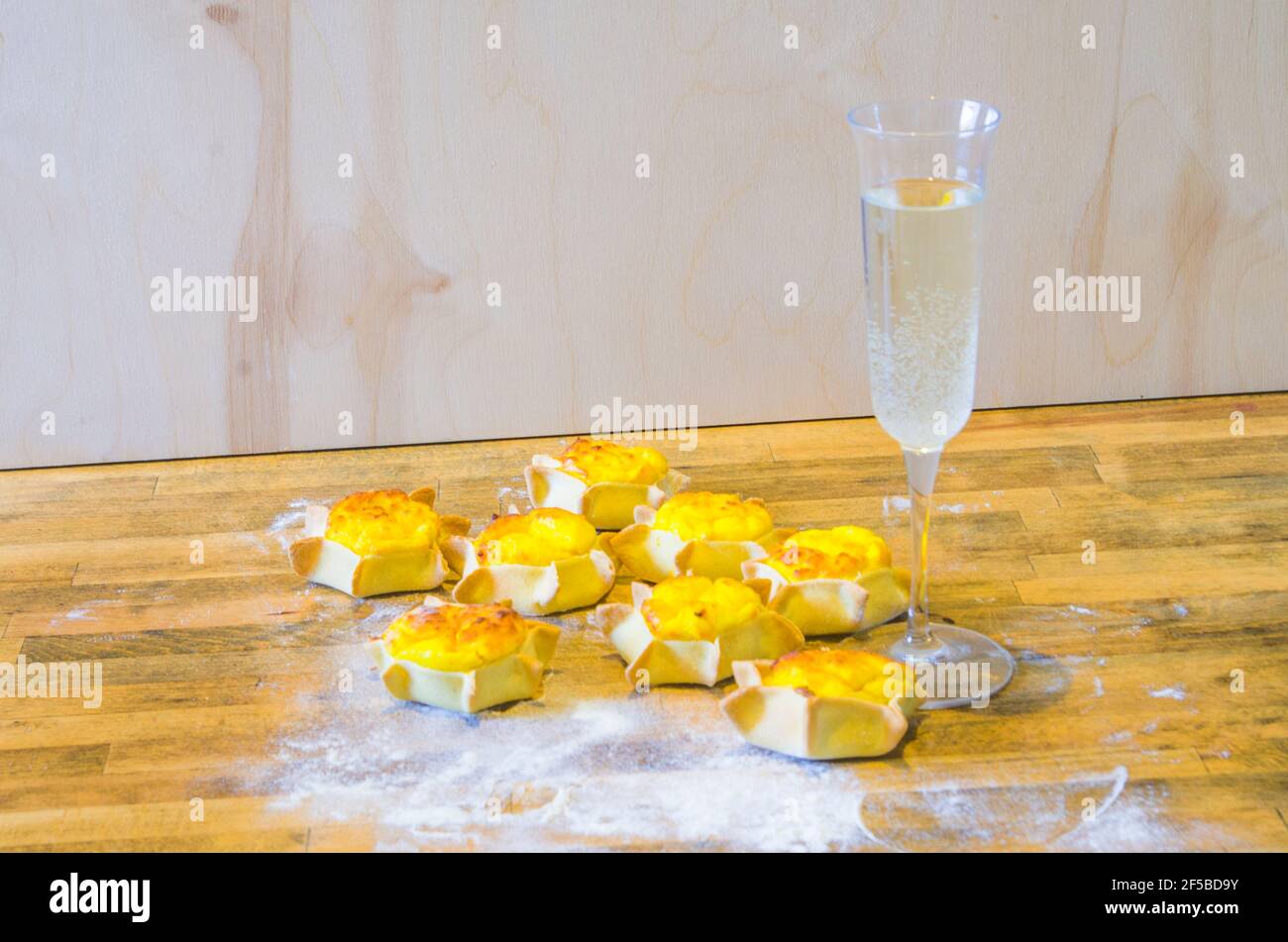 glass of iced sparkling wine with starshaped sweets with shortcrust