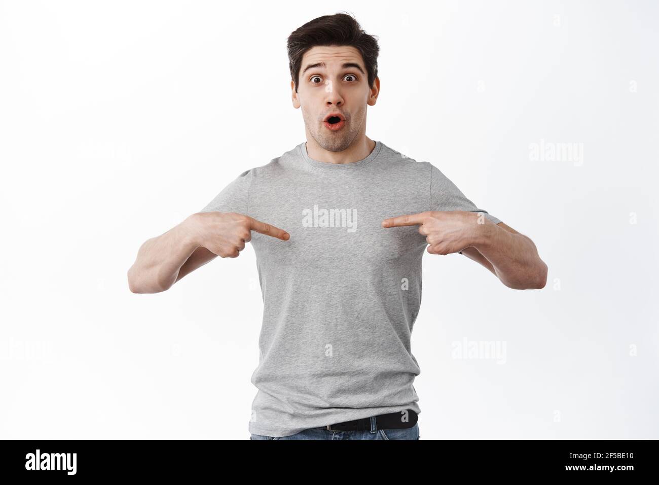 Portrait of surprised adult man pointing at himself and looking amazed ...