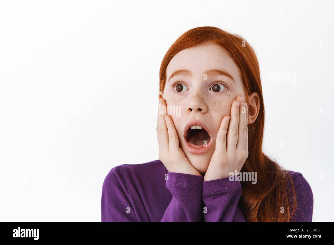 Surprised redhead little kid, girl with ginger hair and freckles
