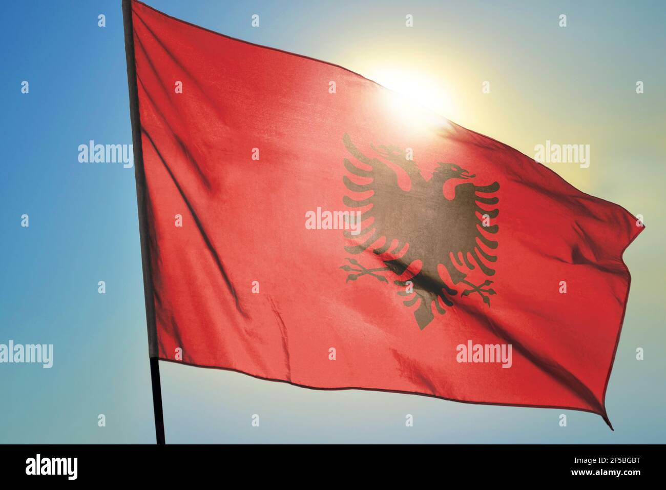 Albania flag waving on the wind in front of sun Stock Photo - Alamy